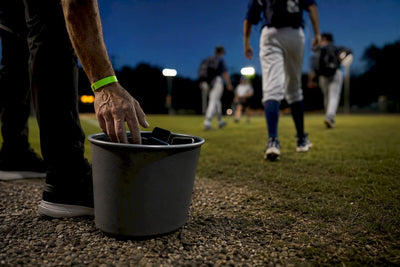 Coach placing phones in sideline collection bucket